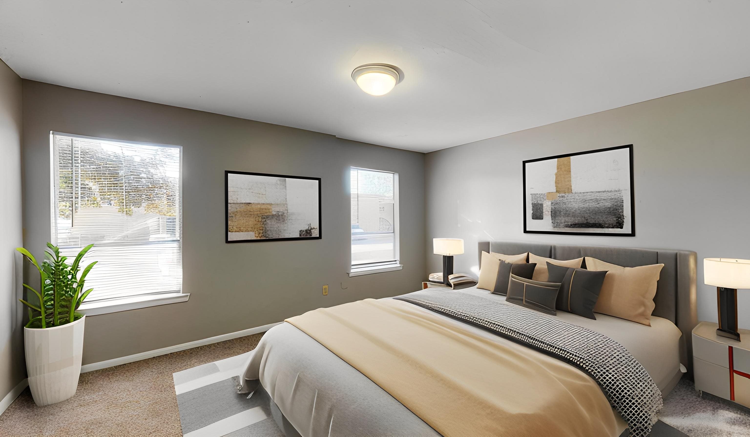 A bedroom with a large bed and two framed pictures on the wall.